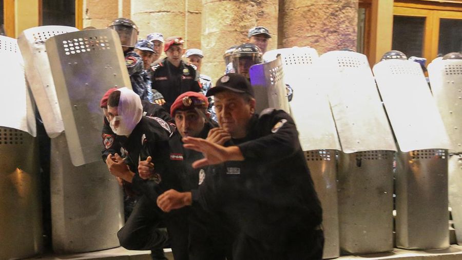 Protesters sit in front of law enforcement officers near the government building during a rally to support ethnic Armenians in Nagorno-Karabakh following Azerbaijani armed forces' offensive operation executed in the region, in Yerevan, Armenia, September 20, 2023. REUTERS/Irakli Gedenidze