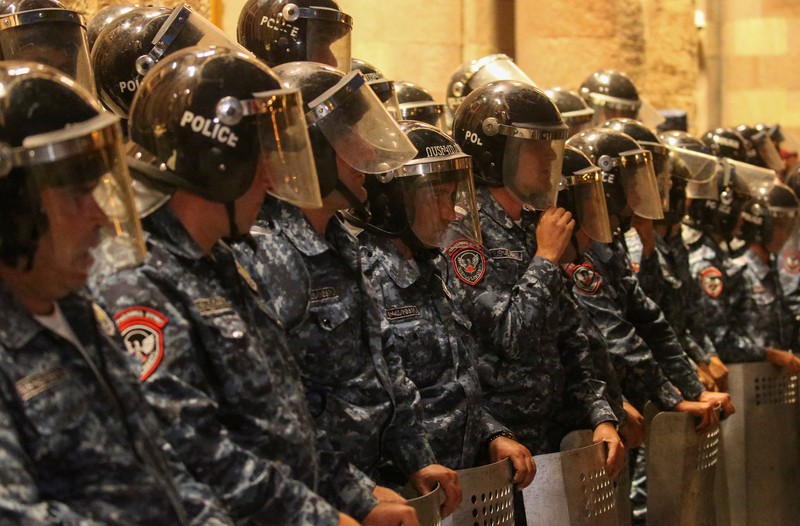 Protesters sit in front of law enforcement officers near the government building during a rally to support ethnic Armenians in Nagorno-Karabakh following Azerbaijani armed forces' offensive operation executed in the region, in Yerevan, Armenia, September 20, 2023. REUTERS/Irakli Gedenidze