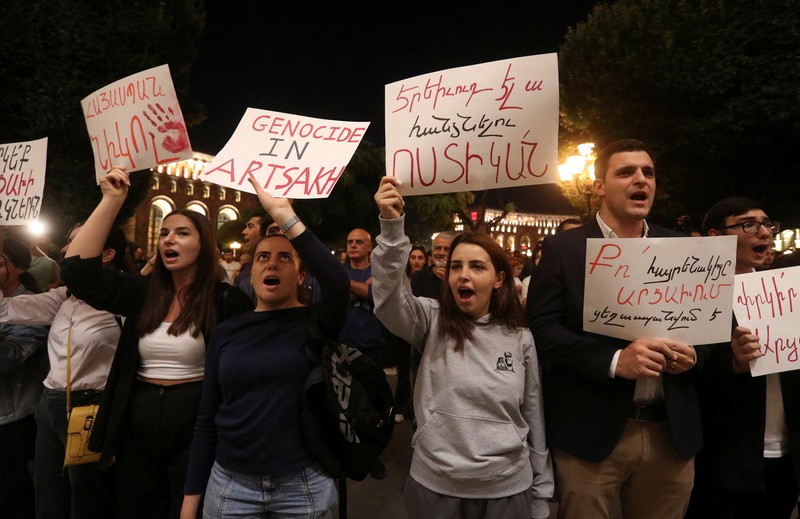 ARMENIA-AZERBAIJAN/PROTESTS Protesters sit in front of law enforcement officers near the government building during a rally to support ethnic Armenians in Nagorno-Karabakh following Azerbaijani armed forces' offensive operation executed in the region, in Yerevan, Armenia, September 20, 2023. REUTERS/Irakli Gedenidze