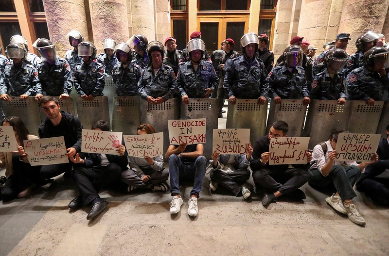 Protesters sit in front of law enforcement officers near the government building during a rally to support ethnic Armenians in Nagorno-Karabakh following Azerbaijani armed forces' offensive operation executed in the region, in Yerevan, Armenia, September 20, 2023. REUTERS/Irakli Gedenidze