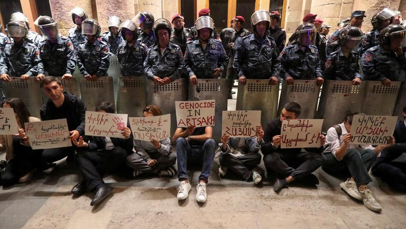 Protesters sit in front of law enforcement officers near the government building during a rally to support ethnic Armenians in Nagorno-Karabakh following Azerbaijani armed forces' offensive operation executed in the region, in Yerevan, Armenia, September 20, 2023. REUTERS/Irakli Gedenidze