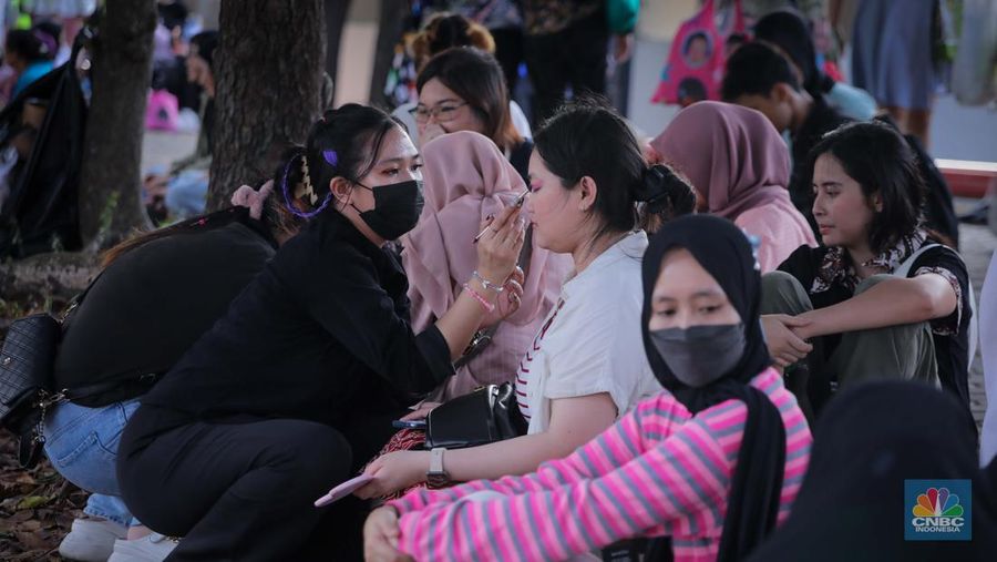 Penonton menggunakan jasa rias wajah saat konser SMTOWN LIVE 2023 SMCU Palace di Stadion Utama Gelora Bung Karno (SUGBK), Senayan Jakarta, Sabtu (23/9/2023). (CNBC Indonesia/Faisal Rahman)