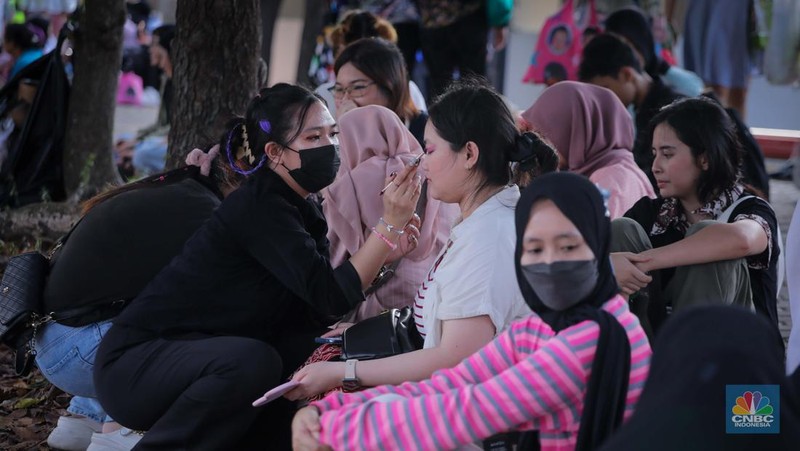 Penonton menggunakan jasa rias wajah saat konser SMTOWN LIVE 2023 SMCU Palace di Stadion Utama Gelora Bung Karno (SUGBK), Senayan Jakarta, Sabtu (23/9/2023). (CNBC Indonesia/Faisal Rahman)