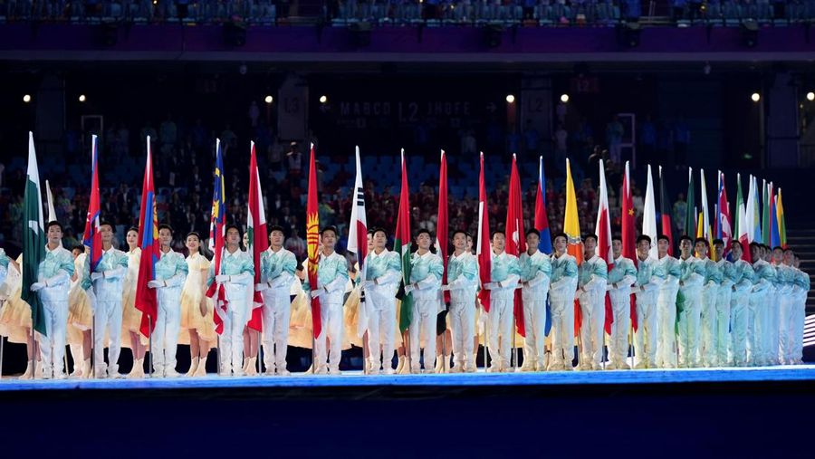 Para pengisi acara memegang bendera negara peserta saat upacara pembukaan Asian Games ke-19 di Hangzhou, China, Sabtu, 23 September 2023. (AP Photo/Vincent Thian)