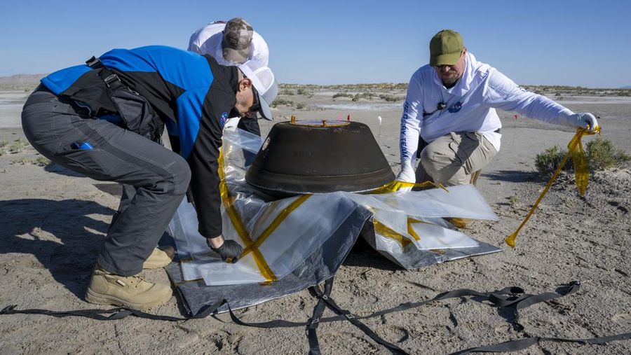 Gambar yang diambil dari video yang disediakan NASA TV ini menunjukkan kapsul yang dilepaskan pesawat luar angkasa Osiris-Rex tergeletak di permukaan setelah mendarat di Bumi, Minggu 24 September 2023. (NASA TV via AP)