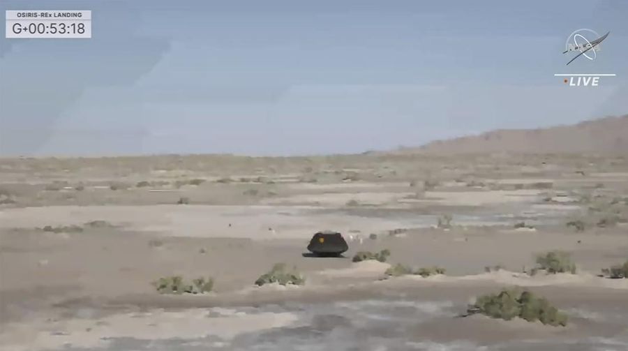 Gambar yang diambil dari video yang disediakan NASA TV ini menunjukkan kapsul yang dilepaskan pesawat luar angkasa Osiris-Rex tergeletak di permukaan setelah mendarat di Bumi, Minggu 24 September 2023. (NASA TV via AP)