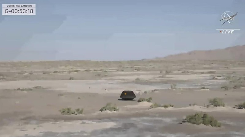 Gambar yang diambil dari video yang disediakan NASA TV ini menunjukkan kapsul yang dilepaskan pesawat luar angkasa Osiris-Rex tergeletak di permukaan setelah mendarat di Bumi, Minggu 24 September 2023. (NASA TV via AP)
