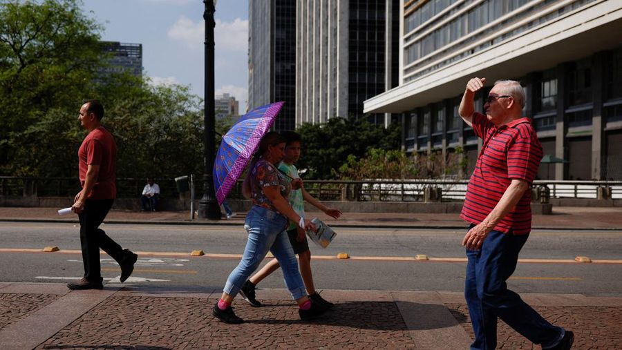Orang-orang menyegarkan diri di kolam renang, saat gelombang panas di Rio de Janeiro, Brasil 24 September 2023. (REUTERS/Pilar Olivares)