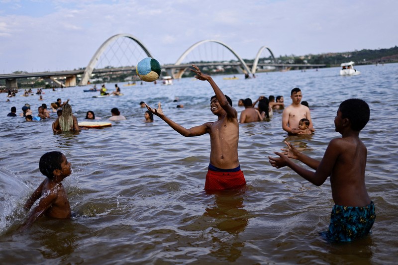 Orang-orang menyegarkan diri di kolam renang, saat gelombang panas di Rio de Janeiro, Brasil 24 September 2023. (REUTERS/Pilar Olivares)