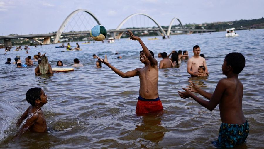 Orang-orang menyegarkan diri di kolam renang, saat gelombang panas di Rio de Janeiro, Brasil 24 September 2023. (REUTERS/Pilar Olivares)