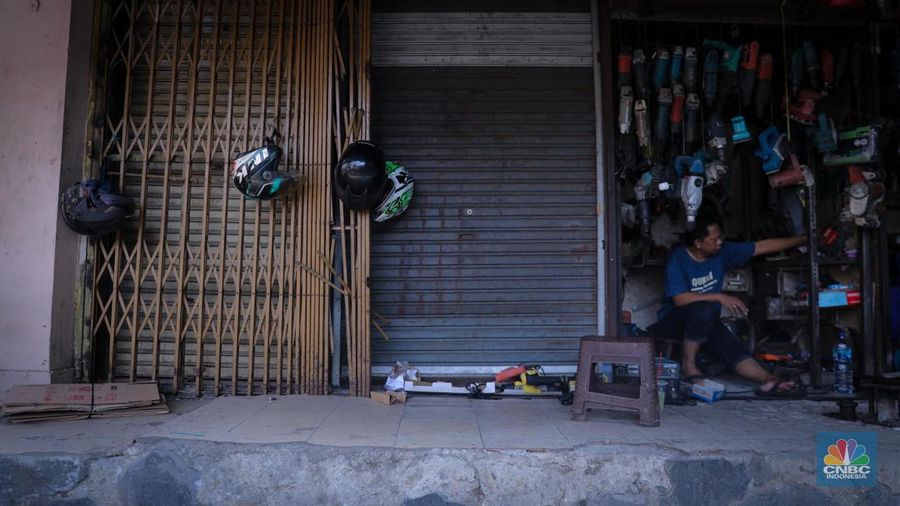 Pedagang sepatu menunggu pembeli di pasar Taman Puring, Kebayoran, Jakarta, Senin (25/9/2023). Pasar Taman Puring yang pada awal tahun 2.000-an menjadi primadona anak muda Jakarta membeli sepatu brand ternama, kini sepi akibat masifnya penjualan online melalaui platform media sosial. (CNBC Indonesia/Faisal Rahman)