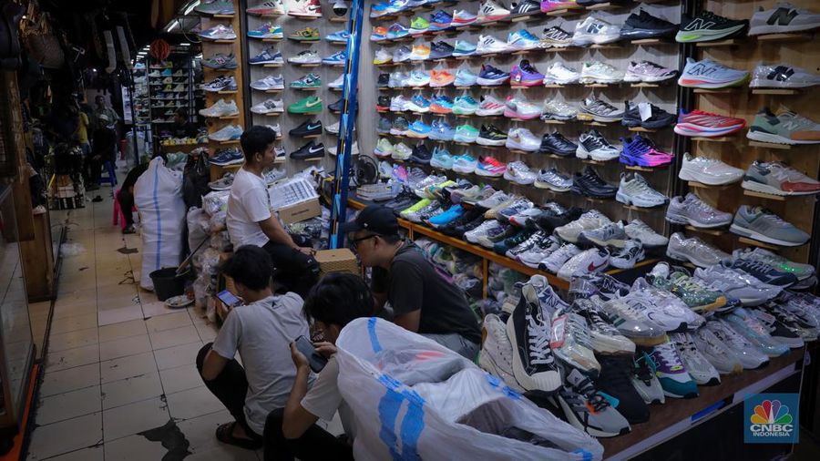 Pedagang sepatu menunggu pembeli di pasar Taman Puring, Kebayoran, Jakarta, Senin (25/9/2023). Pasar Taman Puring yang pada awal tahun 2.000-an menjadi primadona anak muda Jakarta membeli sepatu brand ternama, kini sepi akibat masifnya penjualan online melalaui platform media sosial. (CNBC Indonesia/Faisal Rahman)