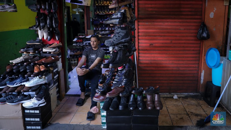 Pedagang sepatu menunggu pembeli di pasar Taman Puring, Kebayoran, Jakarta, Senin (25/9/2023). Pasar Taman Puring yang pada awal tahun 2.000-an menjadi primadona anak muda Jakarta membeli sepatu brand ternama, kini sepi akibat masifnya penjualan online melalaui platform media sosial. (CNBC Indonesia/Faisal Rahman)