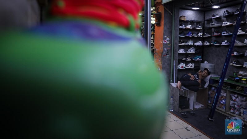 Pedagang sepatu menunggu pembeli di pasar Taman Puring, Kebayoran, Jakarta, Senin (25/9/2023). Pasar Taman Puring yang pada awal tahun 2.000-an menjadi primadona anak muda Jakarta membeli sepatu brand ternama, kini sepi akibat masifnya penjualan online melalaui platform media sosial. (CNBC Indonesia/Faisal Rahman)