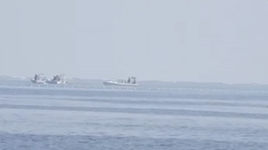 Perahu Penjaga Pantai Tiongkok di dekat penghalang terapung digambarkan pada tanggal 20 September 2023, di dekat Scarborough Shoal di Laut Cina Selatan, dalam gambar selebaran yang dirilis oleh Penjaga Pantai Filipina pada tanggal 24 September 2023. (Tangkapan Layar Video Reuters/PHILIPPINE COAST GUARD HANDOUT)