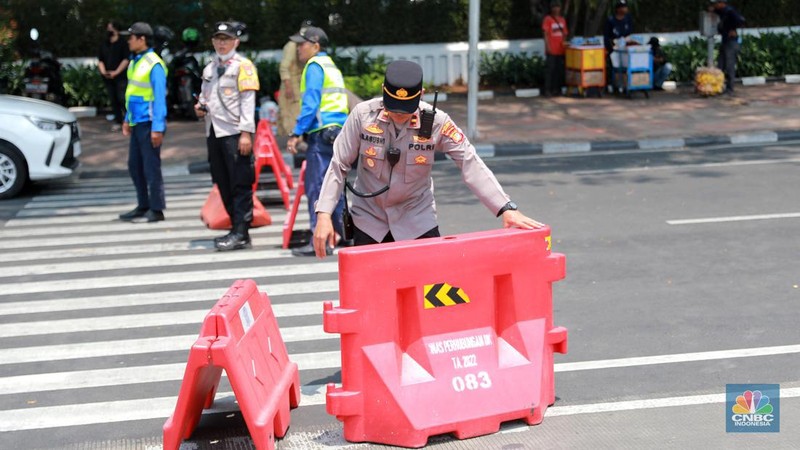 Warga berjalan di persimpangan lampu merah patung kuda, Jakarta, Senin, (25/9). (CNBC Indonesia/Muhammad Sabki)