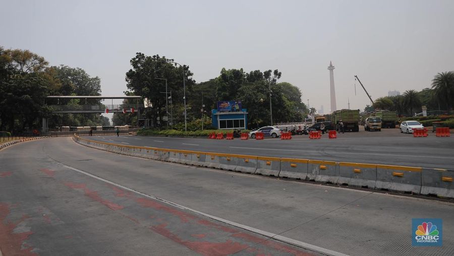 Warga berjalan di persimpangan lampu merah patung kuda, Jakarta, Senin, (25/9). (CNBC Indonesia/Muhammad Sabki)