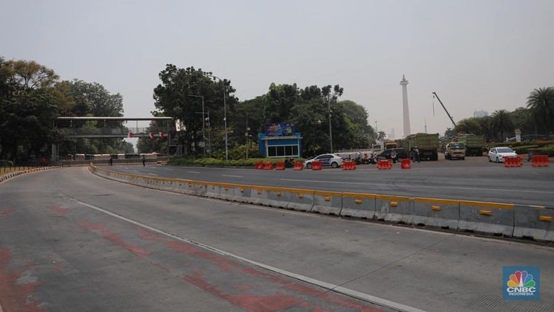 Warga berjalan di persimpangan lampu merah patung kuda, Jakarta, Senin, (25/9). (CNBC Indonesia/Muhammad Sabki)