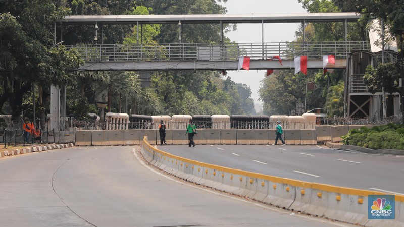 Warga berjalan di persimpangan lampu merah patung kuda, Jakarta, Senin, (25/9). (CNBC Indonesia/Muhammad Sabki)