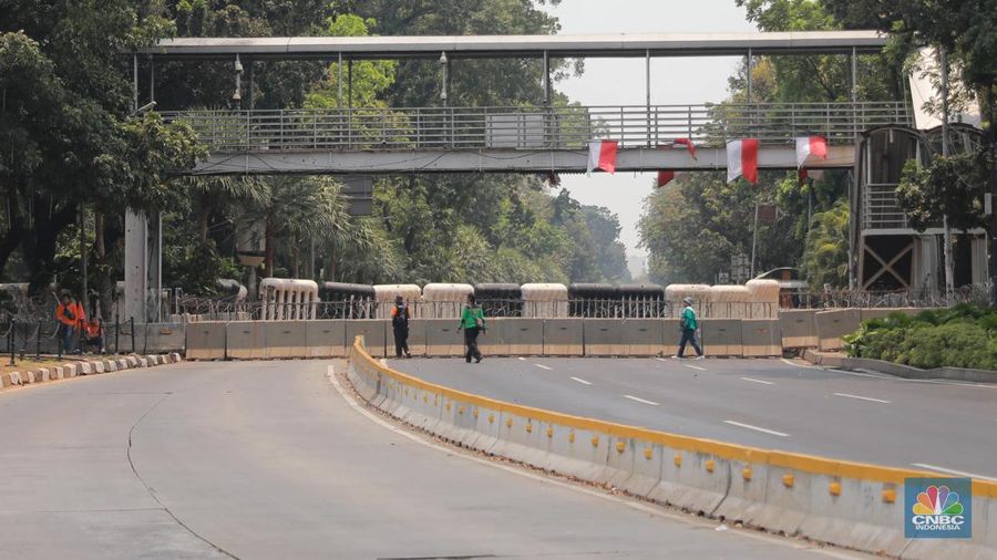 Warga berjalan di persimpangan lampu merah patung kuda, Jakarta, Senin, (25/9). (CNBC Indonesia/Muhammad Sabki)