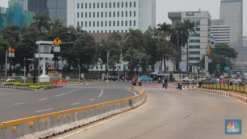 Warga berjalan di persimpangan lampu merah patung kuda, Jakarta, Senin, (25/9). Warga berjalan di persimpangan lampu merah patung kuda, Jakarta, Senin, (25/9). (CNBC Indonesia/Muhammad Sabki)