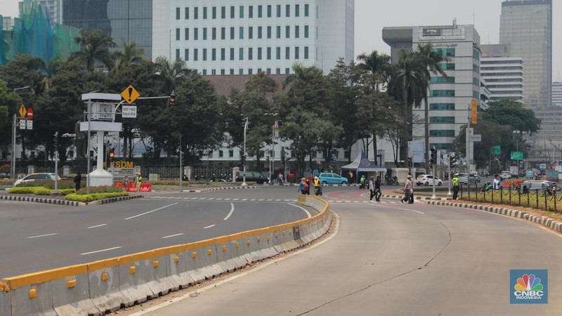 Warga berjalan di persimpangan lampu merah patung kuda, Jakarta, Senin, (25/9). (CNBC Indonesia/Muhammad Sabki)