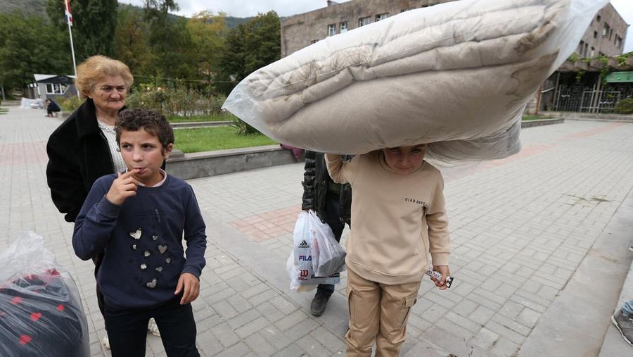 Warga berkumpul di samping bus di pusat Stepanakert sebelum meninggalkan Nagorno-Karabakh, wilayah yang dihuni etnis Armenia, 25 September 2023. (REUTERS/David Ghahramanyan)