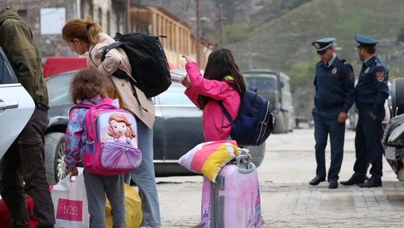 Warga berkumpul di samping bus di pusat Stepanakert sebelum meninggalkan Nagorno-Karabakh, wilayah yang dihuni etnis Armenia, 25 September 2023. (REUTERS/David Ghahramanyan)