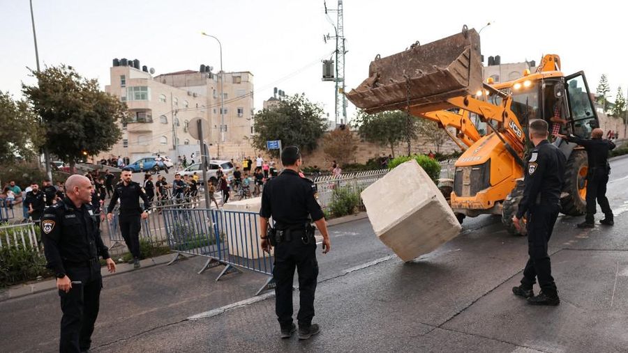 Polisi Israel menempatkan blok semen di seberang jalan yang menghubungkan lingkungan Arab Beit Hanina di Yerusalem timur dengan Yerusalem barat sebelum dimulainya Yom Kippur (Hari Pendamaian), hari terpenting dalam kalender Yahudi yang dimulai saat matahari terbenam, pada 24 September 2023 . (Photo by AHMAD GHARABLI / AFP)