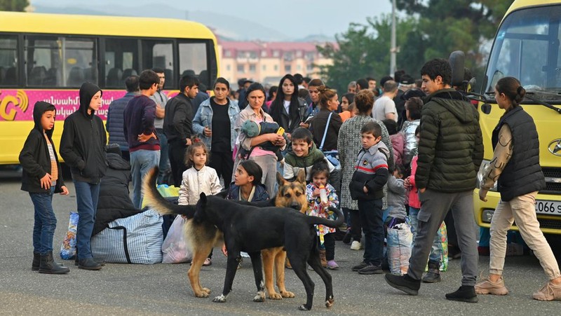 Warga berkumpul di samping bus di pusat Stepanakert sebelum meninggalkan Nagorno-Karabakh, wilayah yang dihuni etnis Armenia, 25 September 2023. (REUTERS/David Ghahramanyan)