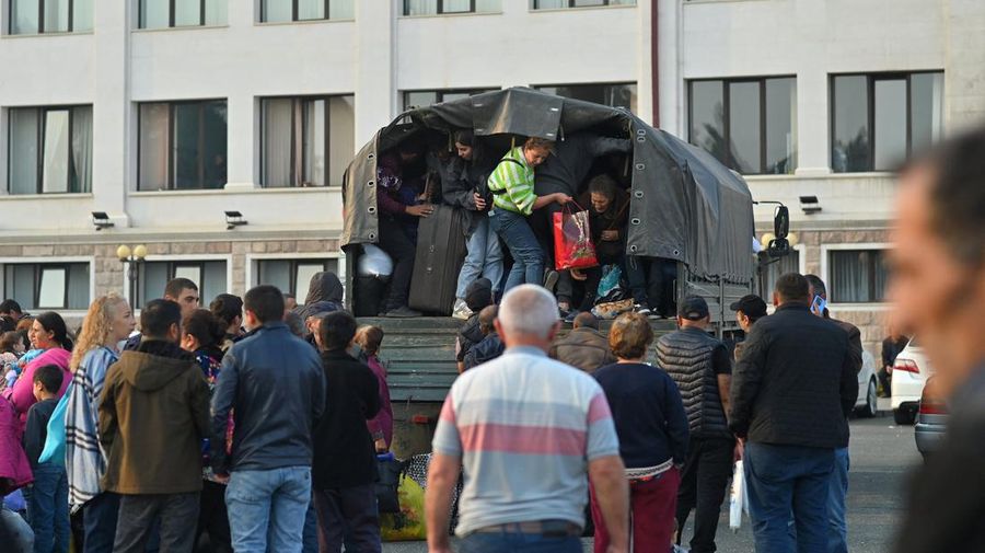 Warga berkumpul di samping bus di pusat Stepanakert sebelum meninggalkan Nagorno-Karabakh, wilayah yang dihuni etnis Armenia, 25 September 2023. (REUTERS/David Ghahramanyan)