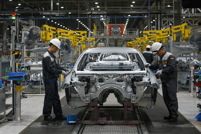 Two men walk outside the main entrance of VinFast, an automotive startup manufacturer in Hai Phong, Vietnam Wednesday, Feb. 27, 2019. As North Korean leader Kim Jong Un prepared for his second summit with President Donald Trump, top members of his delegation made a whirlwind tour of one of Vietnam’s most successful conglomerates. (AP Photo/Minh Hoang)