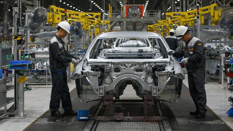 Two men walk outside the main entrance of VinFast, an automotive startup manufacturer in Hai Phong, Vietnam Wednesday, Feb. 27, 2019. As North Korean leader Kim Jong Un prepared for his second summit with President Donald Trump, top members of his delegation made a whirlwind tour of one of Vietnam’s most successful conglomerates. (AP Photo/Minh Hoang)