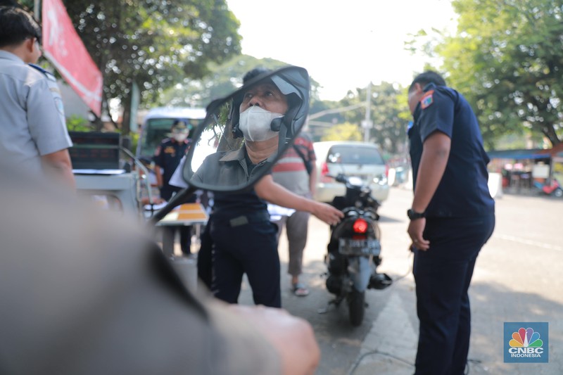 Petugas melakukan uji emisi sepeda motor dengan menggunakan alat uji yang diberikan gratis kepada warga oleh Unit Pengelola Pengujian Kendaraan Bermotor (UP PKB) Jagakarsa di Terminal Bus Ragunan, Jalan Saco, Pasar Minggu, Jakarta Selatan, Rabu (27/9/2023). (CNBC Indonesia/Muhammad Sabki)
