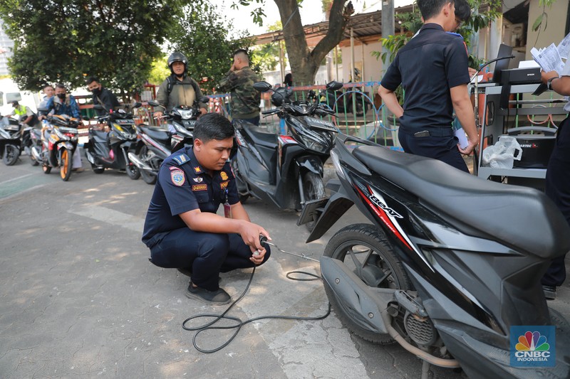 Petugas melakukan uji emisi sepeda motor dengan menggunakan alat uji yang diberikan gratis kepada warga oleh Unit Pengelola Pengujian Kendaraan Bermotor (UP PKB) Jagakarsa di Terminal Bus Ragunan, Jalan Saco, Pasar Minggu, Jakarta Selatan, Rabu (27/9/2023). (CNBC Indonesia/Muhammad Sabki)