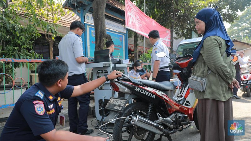 Petugas melakukan uji emisi sepeda motor dengan menggunakan alat uji yang diberikan gratis kepada warga oleh Unit Pengelola Pengujian Kendaraan Bermotor (UP PKB) Jagakarsa di Terminal Bus Ragunan, Jalan Saco, Pasar Minggu, Jakarta Selatan, Rabu (27/9/2023). (վ/Muhammad Sabki)