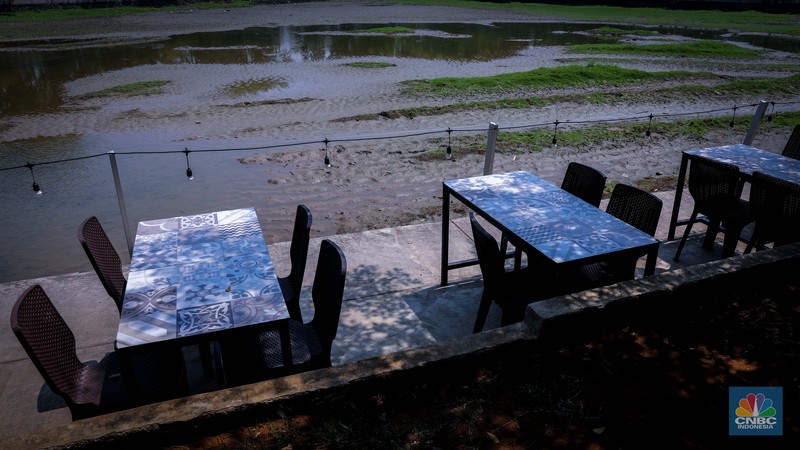 Seorang warga berjalan di tanah yang retak akibat kekeringan di Danau Cinere, Depok, Jawa Barat, Rabu (27/9/2023). (CNBC Indonesia/Faisal Rahman)