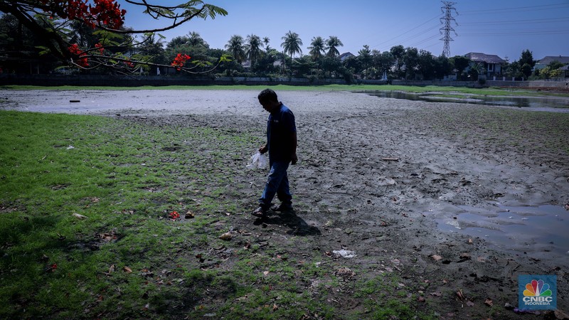 Seorang warga berjalan di tanah yang retak akibat kekeringan di Danau Cinere, Depok, Jawa Barat, Rabu (27/9/2023). Seorang warga berjalan di tanah yang retak akibat kekeringan di Danau Cinere, Depok, Jawa Barat, Rabu (27/9/2023). (CNBC Indonesia/Faisal Rahman)