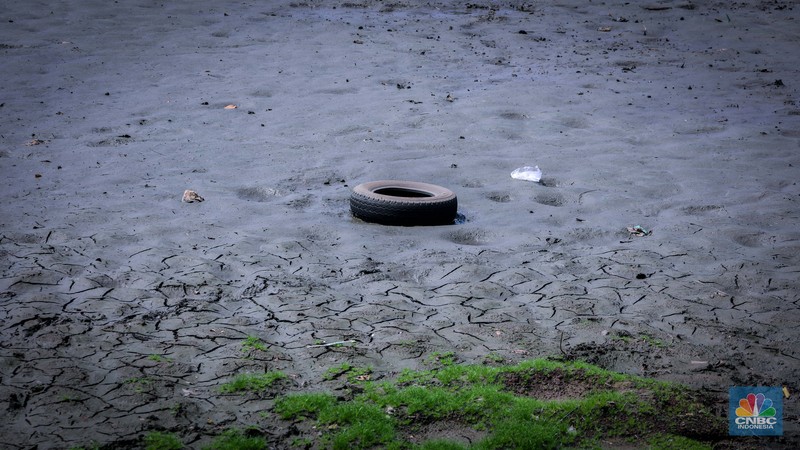 Seorang warga berjalan di tanah yang retak akibat kekeringan di Danau Cinere, Depok, Jawa Barat, Rabu (27/9/2023). Seorang warga berjalan di tanah yang retak akibat kekeringan di Danau Cinere, Depok, Jawa Barat, Rabu (27/9/2023). (CNBC Indonesia/Faisal Rahman)