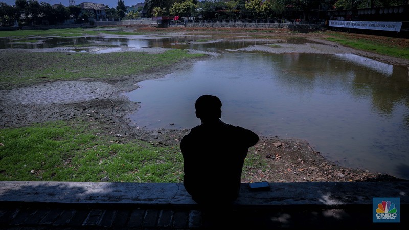 Seorang warga berjalan di tanah yang retak akibat kekeringan di Danau Cinere, Depok, Jawa Barat, Rabu (27/9/2023). Seorang warga berjalan di tanah yang retak akibat kekeringan di Danau Cinere, Depok, Jawa Barat, Rabu (27/9/2023). (CNBC Indonesia/Faisal Rahman)