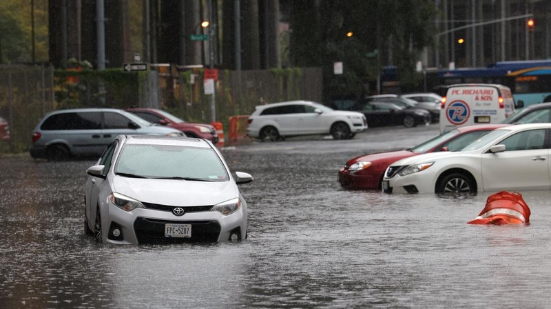 A police officer from the NYPD Highway Patrol looks to motorists drive through a flooded street after heavy rains as the remnants of Tropical Storm Ophelia bring flooding across the mid-Atlantic and Northeast, at the FDR Drive in Manhattan near the Williamsburg Bridge, in New York City, U.S., September 29, 2023.  REUTERS/Andrew Kelly     TPX IMAGES OF THE DAY