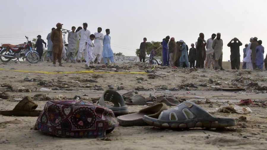Penduduk setempat berdiri di lokasi ledakan bom bunuh diri di Mastung dekat Quetta, Pakistan, Jumat, 29 September 2023. Pihak berwenang di Pakistan mengatakan sedikitnya 52 orang tewas dan hampir 70 luka-luka setelah seorang tersangka pembom meledakkan dirinya di tengah kerumunan orang. orang-orang merayakan Maulid Nabi Muhammad di barat daya negara itu. (AP Photo/Arshad Butt)