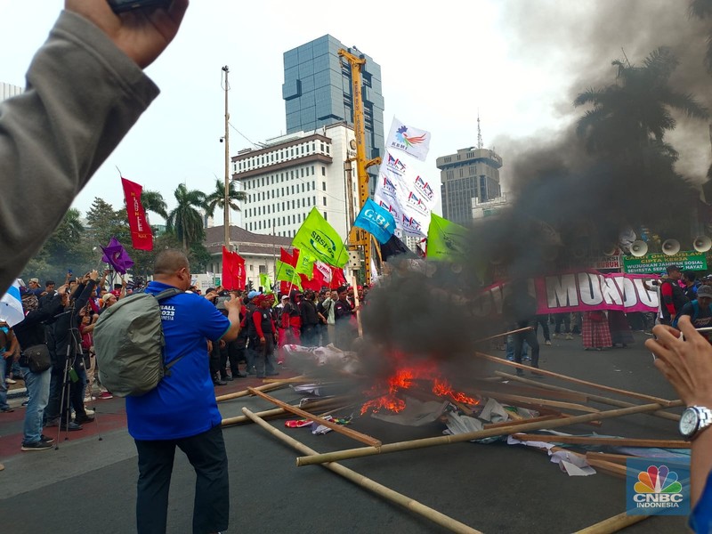 Buruh melakikan aksi bakr-bakaran saat demo di Patung Kuda, Monas, Jakarta, Senin (2/10/2023). (CNBC Indonesia/Martyasari Rizky)