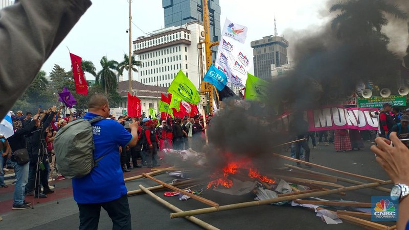 Buruh melakikan aksi bakr-bakaran saat demo di Patung Kuda, Monas, Jakarta, Senin (2/10/2023). (CNBC Indonesia/Martyasari Rizky)