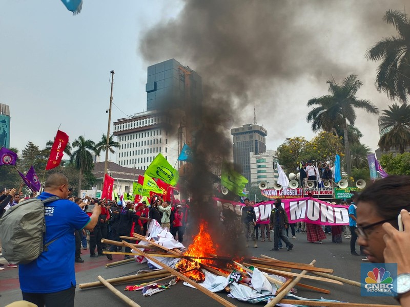 Buruh melakikan aksi bakr-bakaran saat demo di Patung Kuda, Monas, Jakarta, Senin (2/10/2023). (CNBC Indonesia/Martyasari Rizky)