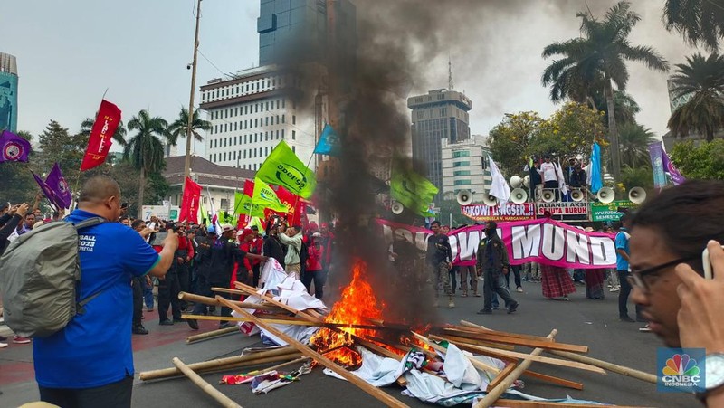 Buruh melakikan aksi bakr-bakaran saat demo di Patung Kuda, Monas, Jakarta, Senin (2/10/2023). (CNBC Indonesia/Martyasari Rizky)