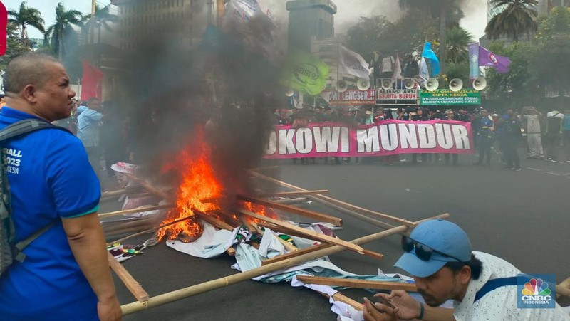Buruh melakikan aksi bakr-bakaran saat demo di Patung Kuda, Monas, Jakarta, Senin (2/10/2023). (CNBC Indonesia/Martyasari Rizky)