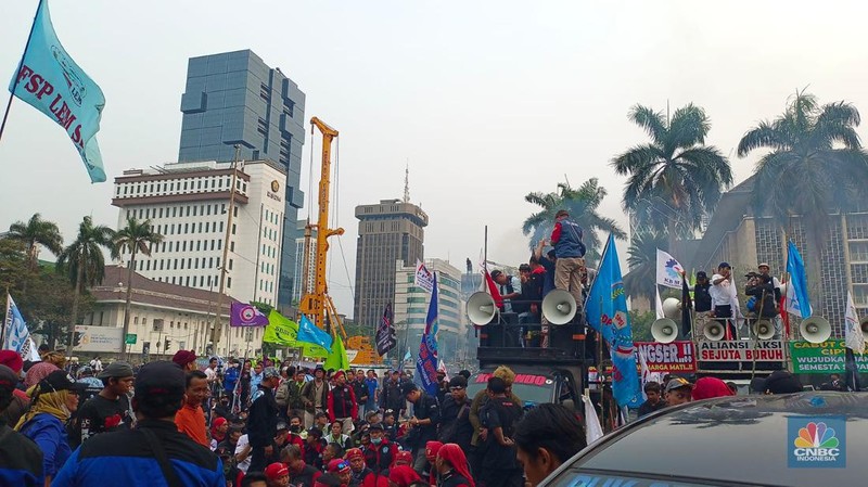 Buruh melakikan aksi bakr-bakaran saat demo di Patung Kuda, Monas, Jakarta, Senin (2/10/2023). (CNBC Indonesia/Martyasari Rizky)