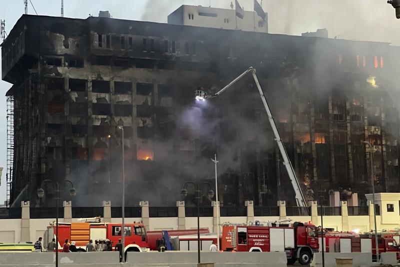 Kepulan asap terlihat dari markas polisi yang terbakar di Ismailia, Timur Laut Mesir. Senin (2/10/2023). (AP Photo/Mohammed Awad)