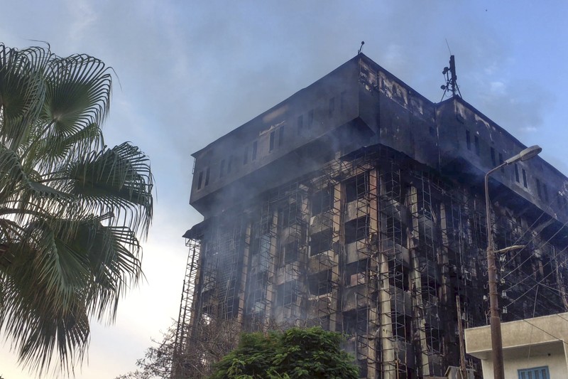 Kepulan asap terlihat dari markas polisi yang terbakar di Ismailia, Timur Laut Mesir. Senin (2/10/2023). (AP Photo/Mohammed Awad)